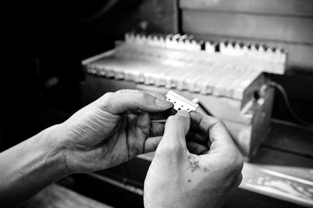 Technician inspecting a precision-ground blade by hand